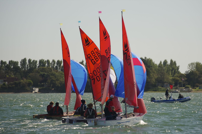 Four Mirror dinghies racing in close company with spinnakers flying