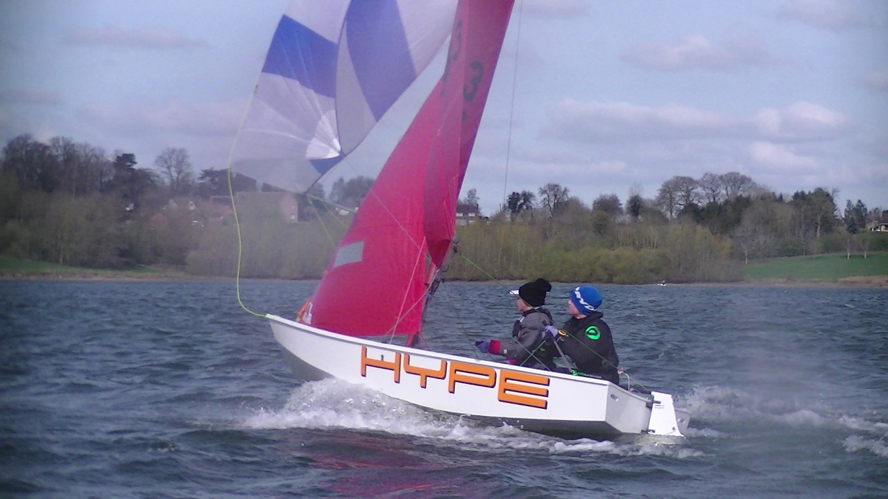 A white Mirror dinghy with spinnaker set
