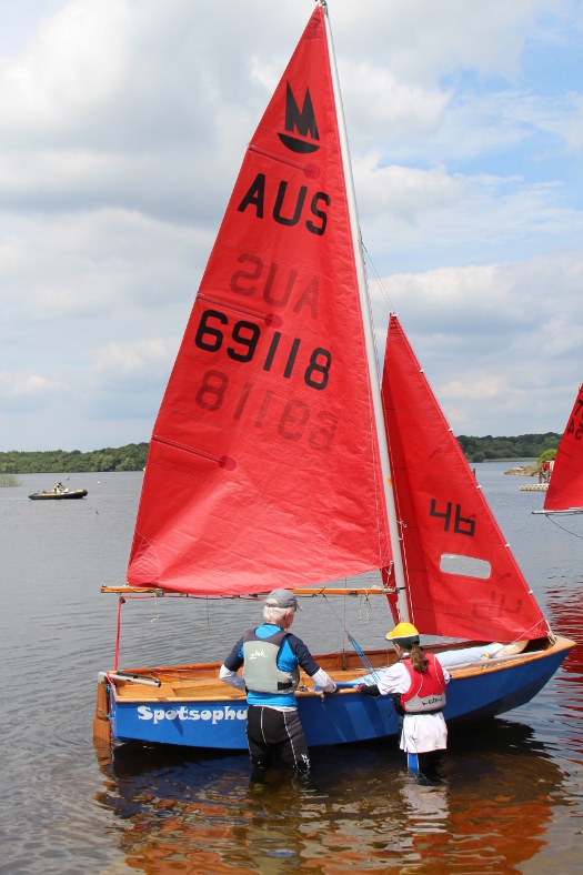 A blue wooden Mirror dinghy with AUS national letters launching