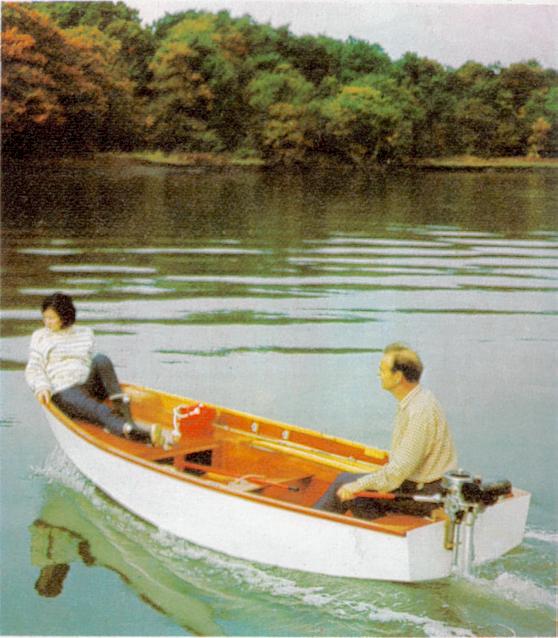 A white Mirror dinghy been propelled by an outboard