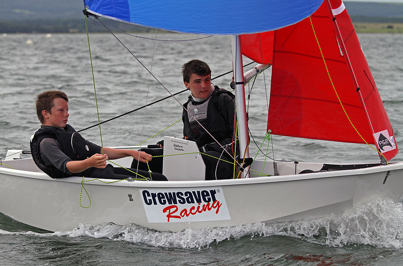 White GRP Mirror dinghy being sailed downwind with the spinnaker up