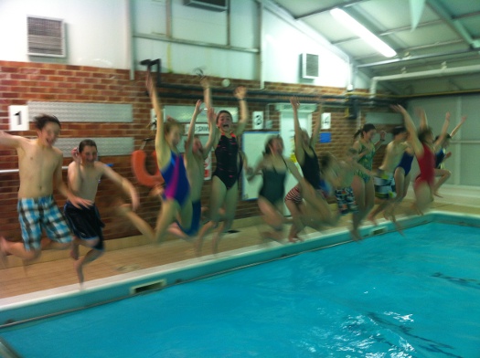 Eighteen children jumping into a swimming pool at once