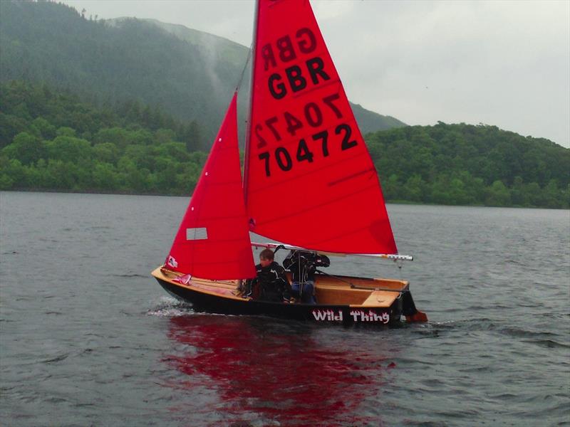 Black wooden Mirror dinghy sailing to windward in a light breeze on a rainy day