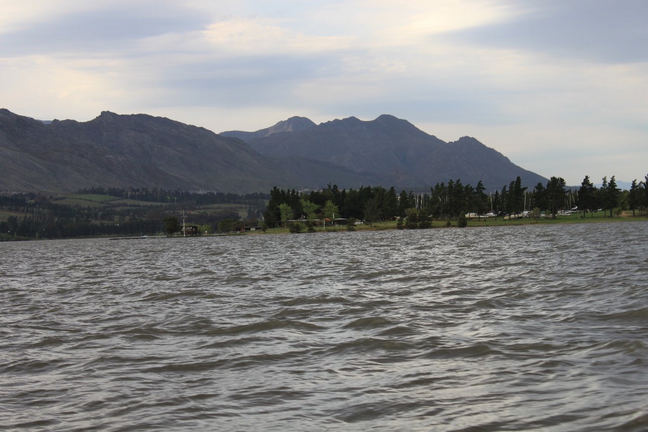 A water sports club viewed from the water with mountains in the background