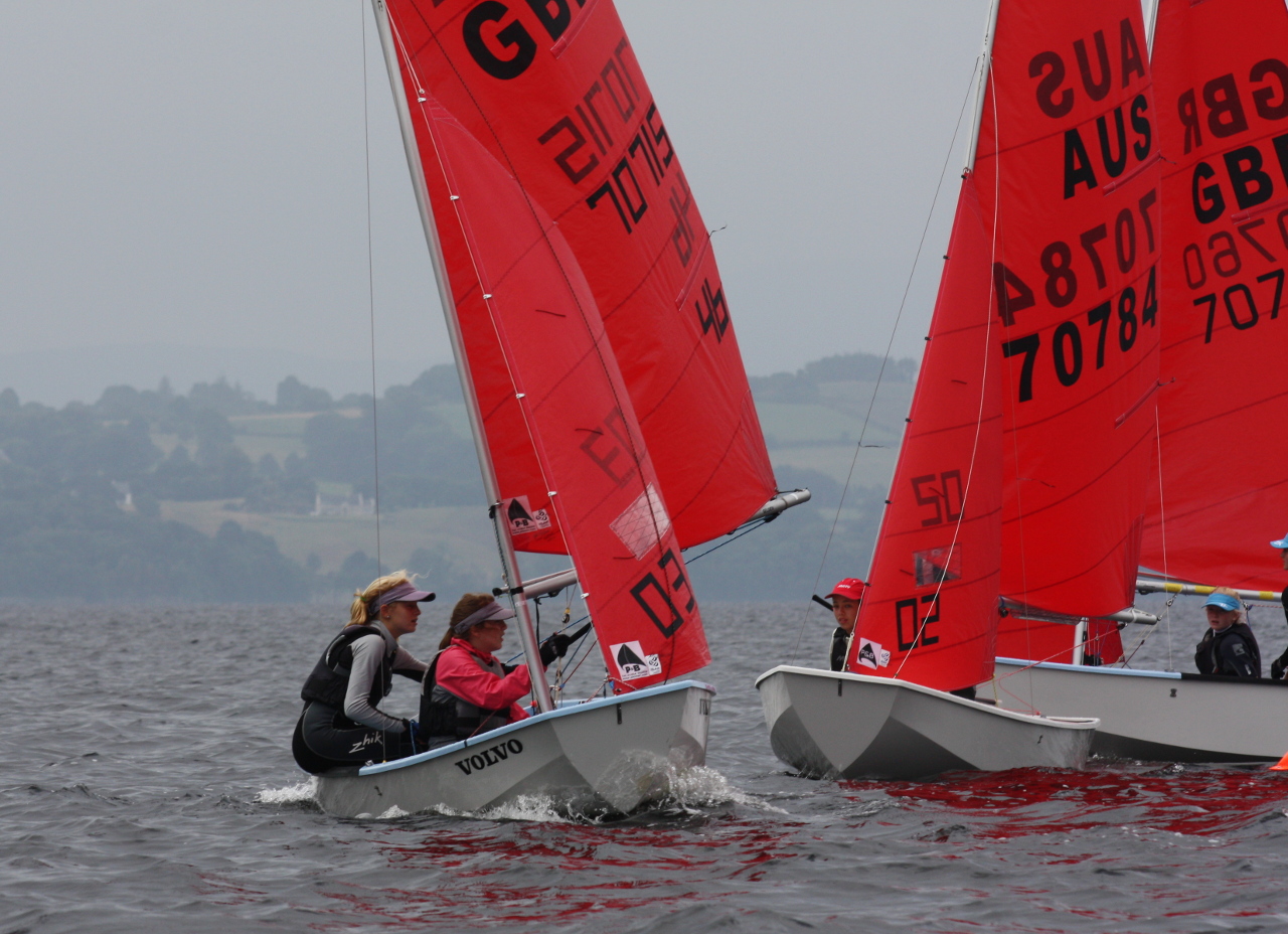 A white GRP Mirror dinghy leading two others around the windward mark