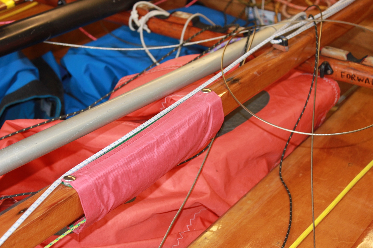 A fabric boom sleeve on a wooden Mirror dinghy boom