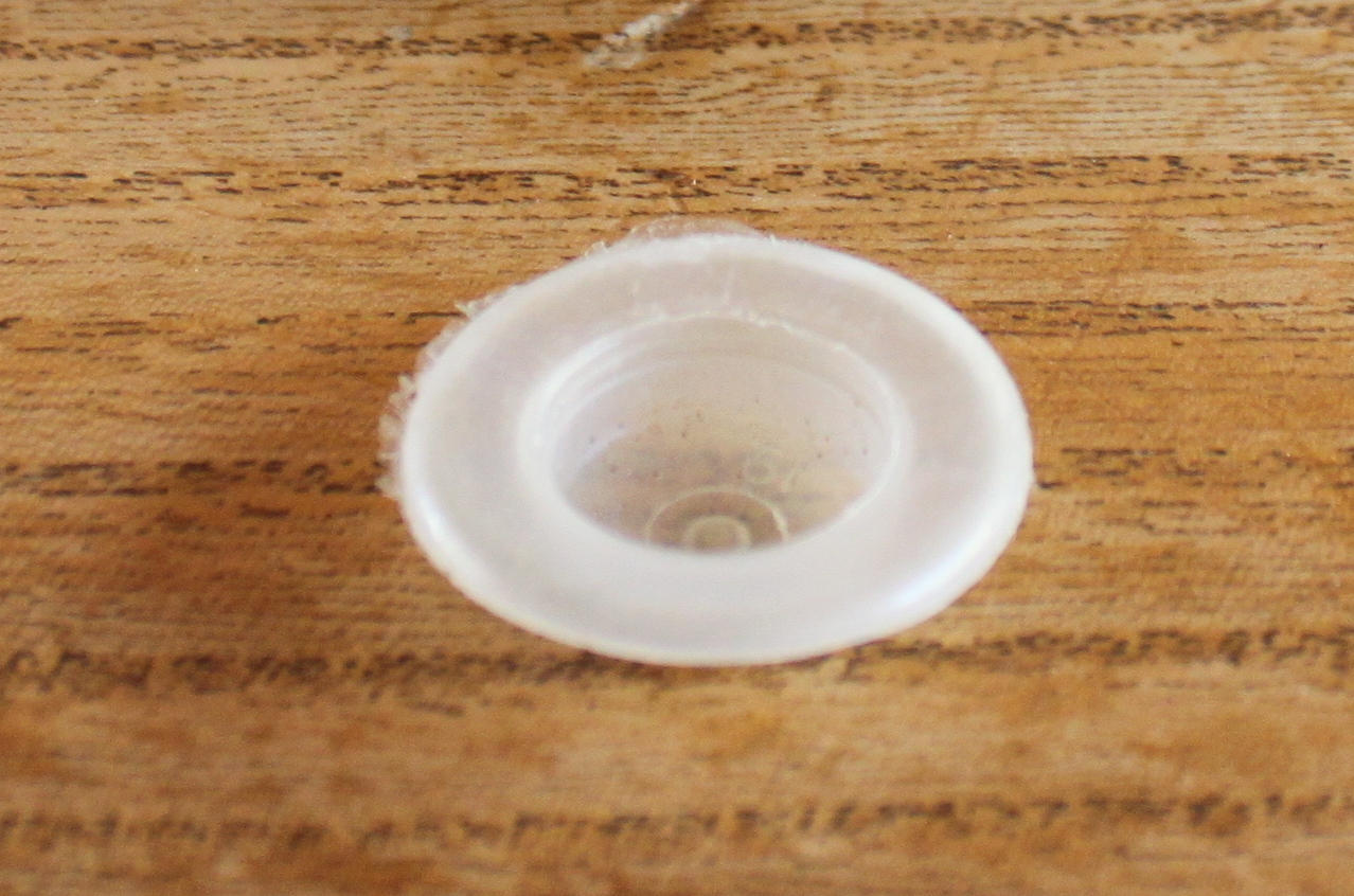 A semi-transparent plastic cap for a drainage hole fitting