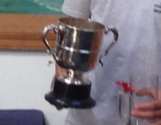 A silver cup with two handles on a black plastic base