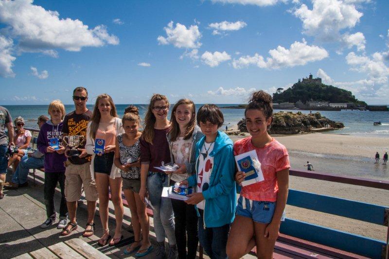 prize winners on a sunny balcony with St Michael's Mount in the background