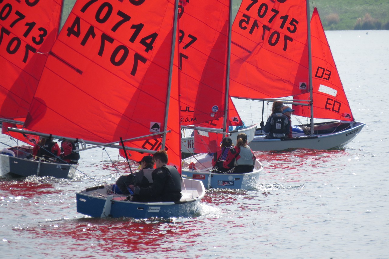 Mirror dinghies on starboard tack on a lake in a light wind