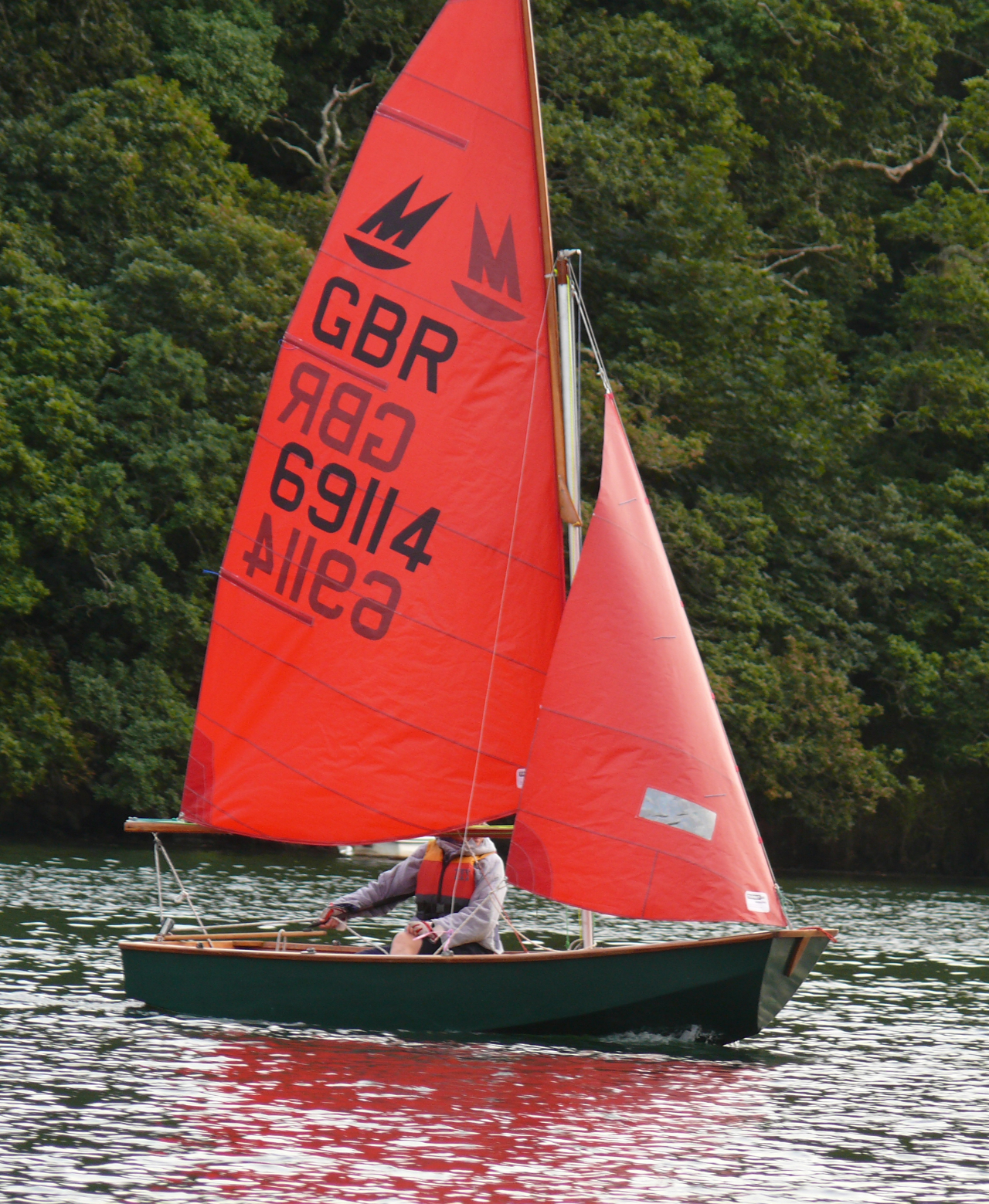 A dark green Mirror being sailed on a river