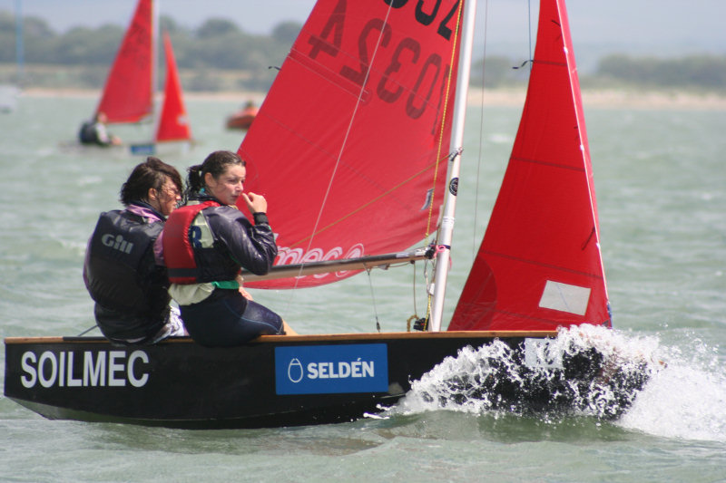 A black wooden Mirror dinghy racing to windward sailed by two girls