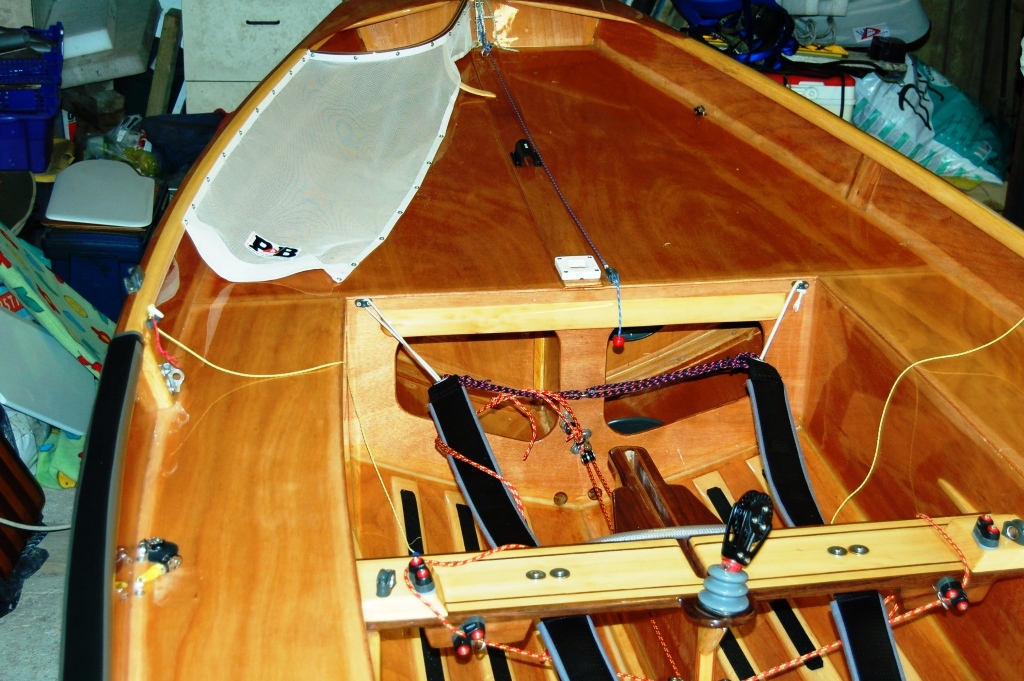 Front section of a Mirror dinghy cockpit showing the crew's toe straps and elastic holding them outboard