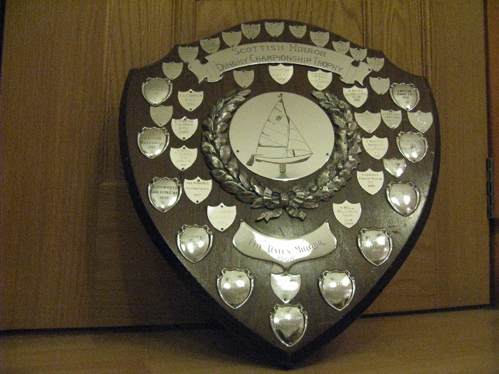A wooden shield with silver shields mounted on it